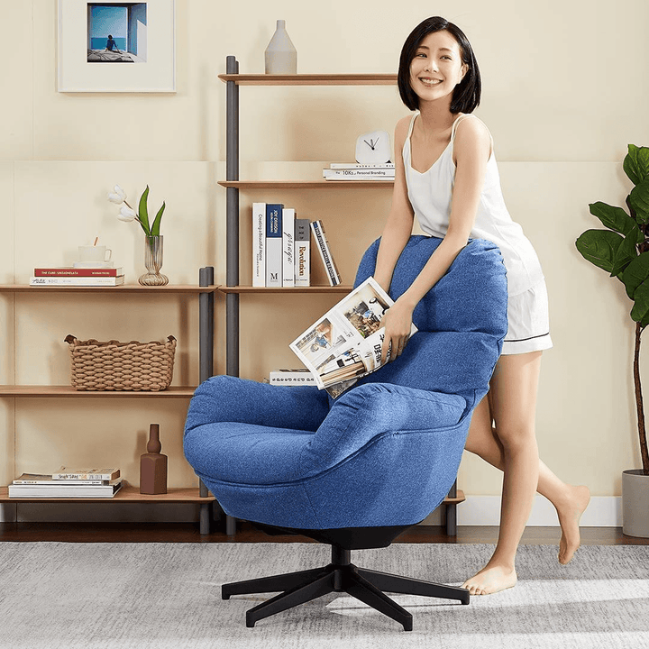 The girl is standing behind the kola ergonomic lounge sofa with her hand on the back of the chair